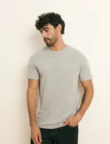 Remera básica de algodón color beige, de manga corta, con cuello redondo y un pequeño detalle bordado en el pecho.
