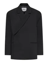 Blazer oversize color negro, con solapa clásica, bolsillos con ribete y diseño amplio de manga larga.