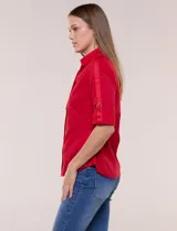 Camisa roja de poplín de algodón, de silueta semi entallada con cuello camisero y escote en V. Cuenta con cierre frontal de botones metálicos, bolsillos plaqué en el pecho y mangas 3/4 arremangables con presilla y argolla metálica.