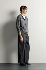 Jeans tapered wide fit de hombre, confeccionados en denim de algodón con efecto lavado en tono azul oscuro. Presentan diseño de cinco bolsillos, tiro medio, corte relajado y cierre frontal con cremallera y botón.