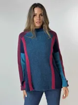 Sweater de punto grueso con cuello alto, diseño de bloques de color en azul marino, azul claro, fucsia y bordó. Presenta mangas largas y un corte holgado.