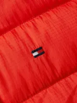 Campera acolchada roja de Tommy Hilfiger con cuello alto, cierre frontal con cremallera, dos bolsillos laterales con cremallera, cordones ajustables en el cuello con detalles distintivos de la marca y logo bordado en el pecho.