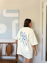 Remerón color crema, de corte oversize, con estampado frontal en azul que dice "LA MAGIA LA LLEVAS CONTIGO".