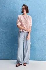 Pantalón cargo celeste de tiro alto y pierna amplia, con bolsillos laterales y bolsillos cargo con tapa.