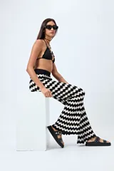 Pantalón tejido con motivo zigzag en blanco y negro, de corte flare y cintura elastizada.
