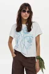Remera blanca de manga corta y corte recto, confeccionada en algodón, con gran estampado botánico en tonos celestes en el frente.