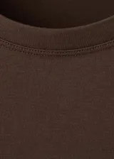 Remera marrón de corte recto, con cuello redondo, manga corta y detalle de bolsillo con bordado en el pecho.