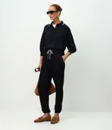 Pantalón tipo jogger de corte holgado con cintura elástica y cordón bicolor ajustable. Presenta puños elásticos en los tobillos y bolsillos laterales.