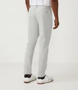 Pantalón de corte slim color gris claro, confeccionado en tejido de poliéster con mezcla de algodón y elastano. Presenta cintura elástica con trabillas, cierre frontal con botón y cremallera, y bolsillos laterales y traseros.