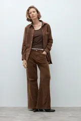 Pantalon de tiro medio y corte wide leg, confeccionado en pana color tostado. Presenta costuras verticales decorativas en el frente y bolsillos laterales.