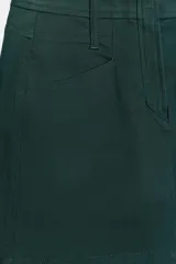 Falda mini de sarga color verde oscuro, de tiro bajo con trabillas en la cintura. Incluye bolsillos delanteros y de plastrón en la espalda. Cierre frontal con cremallera y ganchos metálicos.