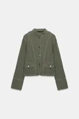 Blazer de cuello mao y manga larga con trabillas en los hombros. Cuenta con falsos bolsillos con solapa en el delantero, costuras pespunteadas a contraste y cierre frontal de botones.