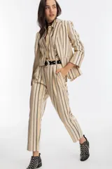 Blazer de jacquard con rayas doradas, negras y crudas, corte clásico, cierre de un botón y mangas largas.