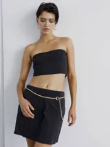 Cinturón dorado de cadena con eslabones entrelazados y dije circular.