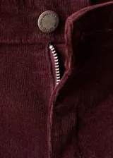Jeans de pana tiro medio color bordó, con diseño flare y cinco bolsillos.