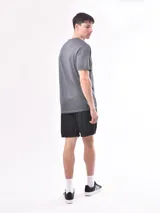 Remera deportiva de manga corta, color gris, con cuello redondo y diseño liso.