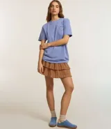 Remera celeste de corte amplio, con cuello redondo y mangas cortas. Estampado en la espalda con un corazón y texto en color azul.