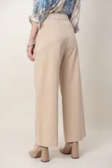 Pantalón beige de corte recto y tiro alto, confeccionado en mezcla de algodón y elastano, con bolsillos laterales y cintura elastizada.