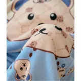 Conjunto de pijama de dos piezas confeccionado en tela de plush suave y abrigada. Incluye una remera de manga larga con diseño estampado de Totoro y pantalón largo a juego con puños en contraste.
