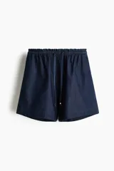 Short de denim liviano, color azul, de tiro alto con cintura elástica fruncida y cordón ajustable con terminales metálicas. Corte holgado.