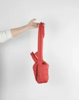 Bandolera azul acolchada con correa ajustable y asa de mano.