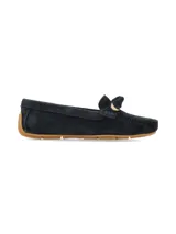 Mocasín de mujer confeccionado en gamuza color azul marino, con detalle de lazo en el empeine y aplique metálico dorado. Presenta suela de goma color suela con diseño de tacos.