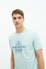 Remera celeste de manga corta con estampado de peces y texto en el frente.