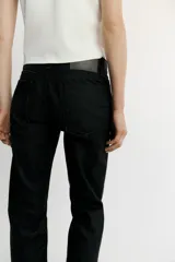 Jeans de tiro bajo y corte recto holgado, con efecto encerado en color negro, cinco bolsillos y trabillas para cinturón. Cierre frontal con cremallera y botón metálico.
