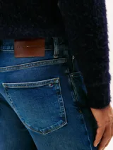 Jean de corte recto con efecto desteñido y lavado desgastado, confeccionado en denim de algodón elástico. Presenta el clásico diseño de cinco bolsillos con detalles distintivos de la marca.