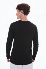 Remera de manga larga en color negro, con cuello redondo y corte moderno.