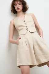 Bermuda color beige de lino con pinzas y bolsillos laterales.