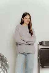 Sweater de punto con textura suave, color gris, de corte holgado, cuello redondo con terminación rulé y mangas largas con puños acanalados.