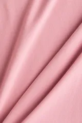Remera de punto suave en color rosado, con diseño entallado, cuello redondo fino ribeteado y mangas cortas.