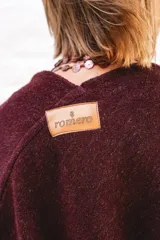 Ruana de lana color negro con terminación de flecos en los bordes y diseño con caída en picos en la espalda.