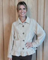 Sobrecamisa de pana color beige, con cuello camisero, cierre frontal de botones, bolsillos delanteros y detalle de volado en el ruedo.