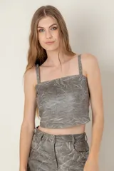 Top de cuero gris con textura arrugada, breteles anchos y espalda descubierta con nudo ajustable.