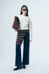 Sweater de punto color bordó con diseño de trenzas y relieves. Presenta cuello redondo, mangas largas y terminaciones acanaladas en puños y ruedo.