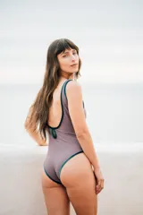 Traje de baño entero color visón con bordes de terciopelo verde inglés y detalle de óvalo en la espalda.