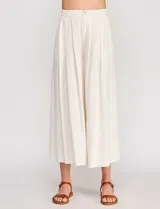 Pantalón palazzo de lino y viscosa, color blanco, de tiro alto y silueta amplia. Presenta pinzas frontales, bolsillos laterales y cierre con botón.