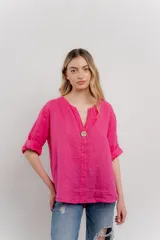 Blusa holgada de lino color verde brillante, con cuello mao abierto y manga corta enrollada. Presenta bordados estilo paisley en tono a tono y un botón de madera en el escote.