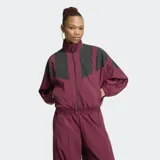 Campera deportiva Adidas modelo Blocking de corte holgado, en color bordó con paneles grises en la parte superior y mangas. Cuenta con cuello alto, cierre frontal completo y bolsillos laterales.