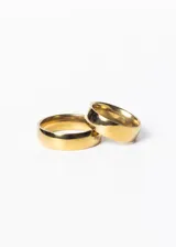 Set de dos alianzas anchas de acero quirúrgico color dorado, con terminación pulida.