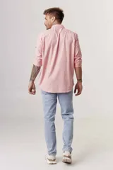 Camisa de hombre color crema, de corte clásico, con cuello abotonado y mangas largas.