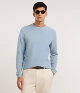 Suéter de punto para hombre, color celeste, con textura acanalada horizontal, cuello redondo y mangas largas con puños ajustados.