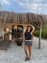 Minifalda dorada de cuero sintético, corte medio/bajo, con cortes en el delantero y pequeño tajo a un lado.