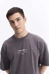 Remera gris de manga corta con escote redondo y estampado de lettering en blanco que dice "Passion Contemporary poetry by mistral".