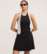 Vestido corto negro de malla punto roma, con escote halter y espalda descubierta. El ruedo es levemente evasé.