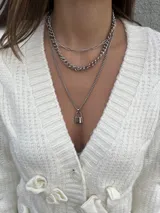 Set de tres collares plateados de diferentes largos. El collar más corto es de eslabones rectangulares, el segundo es de eslabones gruesos y el más largo tiene un dije de candado.