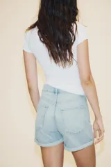 Bermuda de tiro alto confeccionada en denim, con diseño de cinco bolsillos, trabillas para cinturón y bajo con dobladillo vuelto.