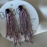Par de aros colgantes con base redonda color borgoña y flecos de canutillos de vidrio color lila.